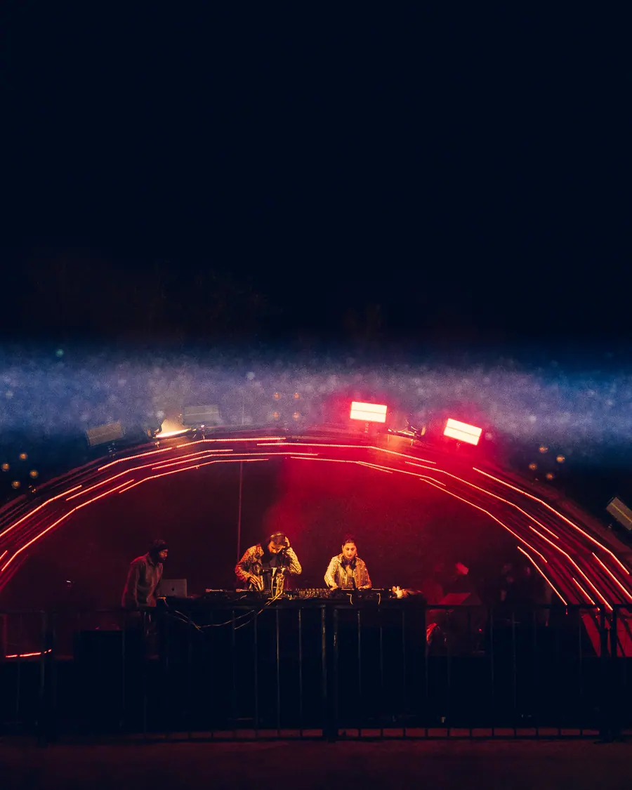 The arch stage glowing red across the open ground