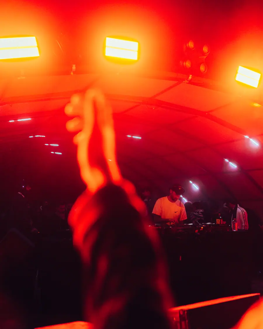 Hands raised under red stage light