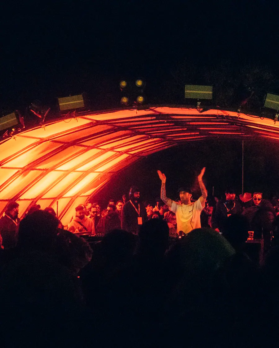 Red glow and silhouettes at the edge of the dancefloor