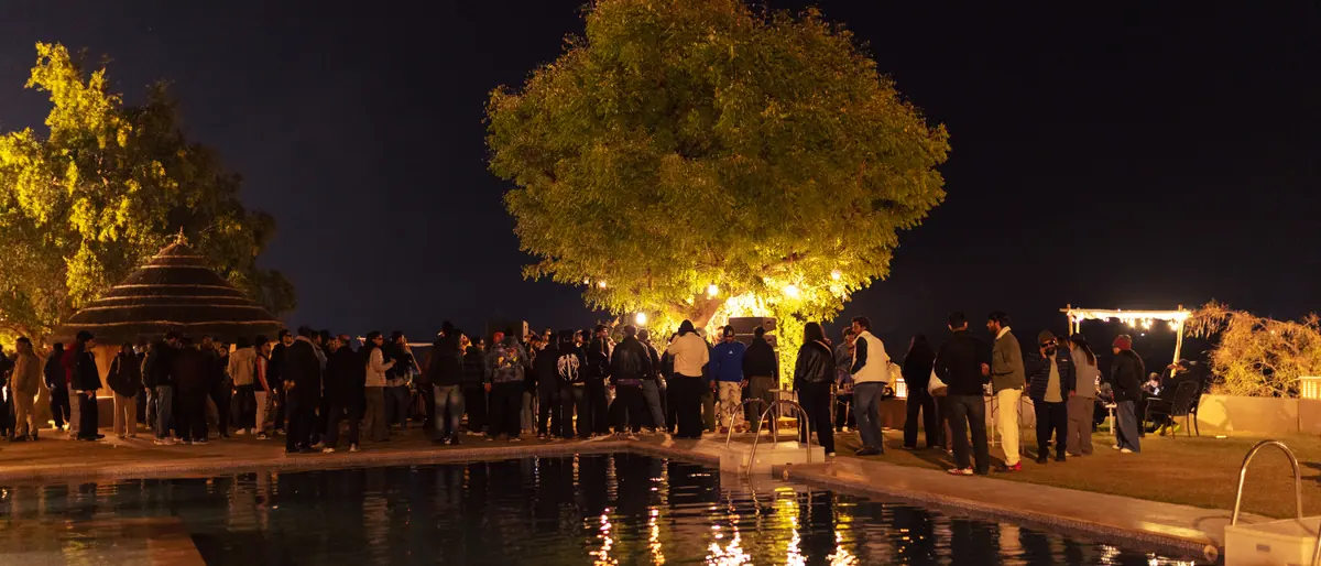 A lit tree reflected in water after dark